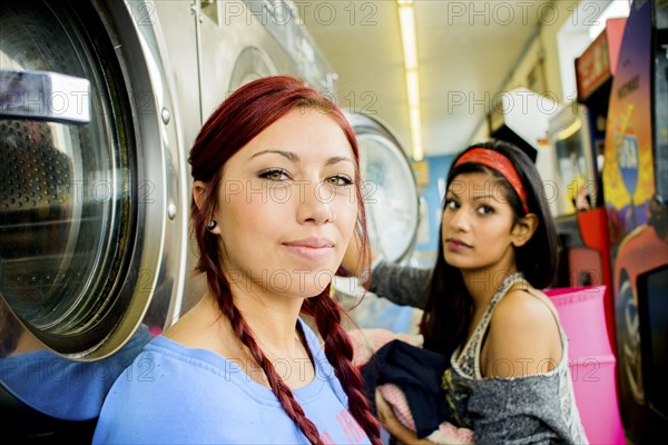 Close up of women washing clothes at laundromat