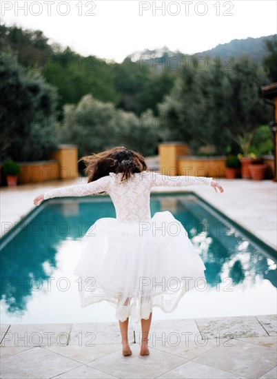 Bride diving into swimming pool