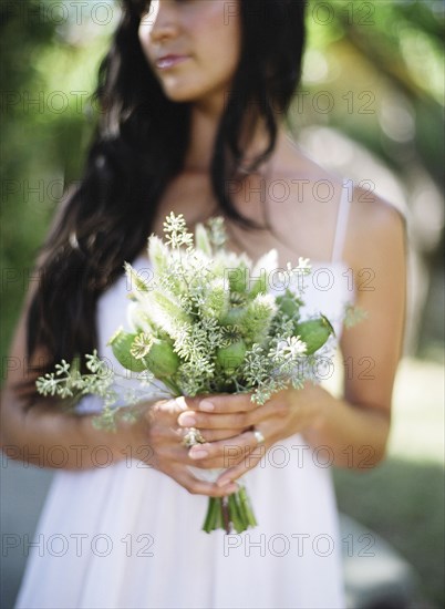 Close up of bride holding bouquet of flowers