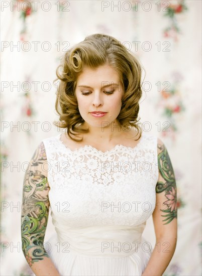 Close up of bride with tattoos wearing wedding dress