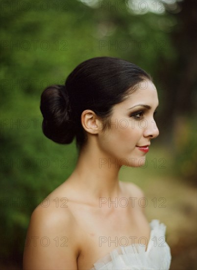 Profile view of bride wearing wedding dress outdoors