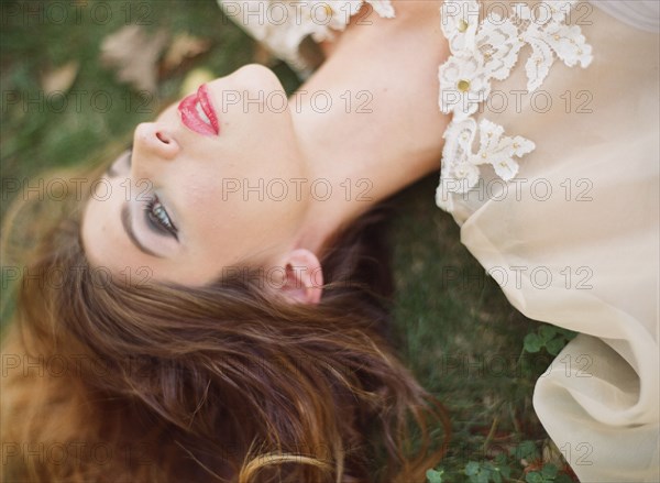 Woman in white blouse laying on lawn