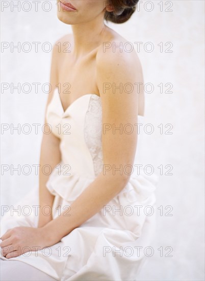 Close up of bride wearing wedding dress