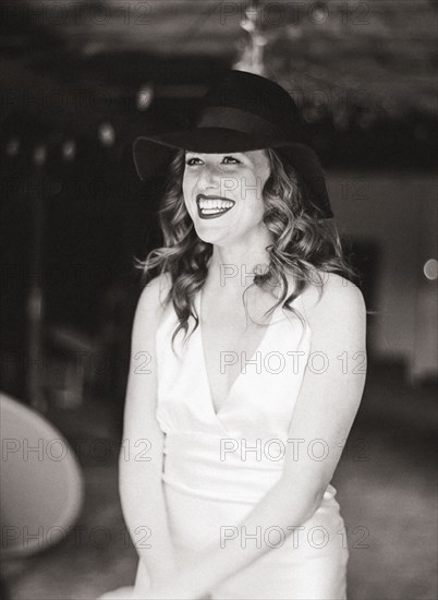 Smiling woman wearing sun hat in backyard