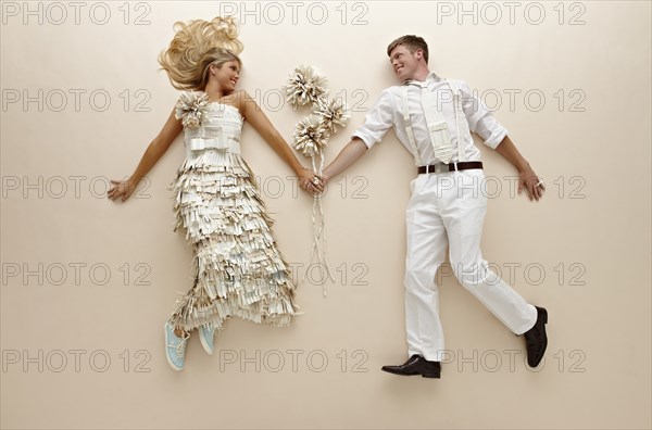 Caucasian couple with flowers laying on floor