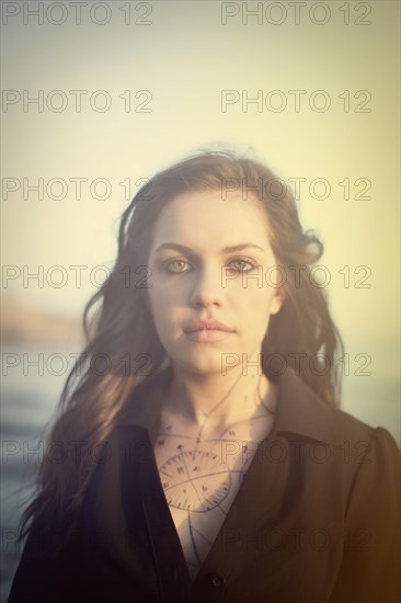 Tattooed woman standing on beach