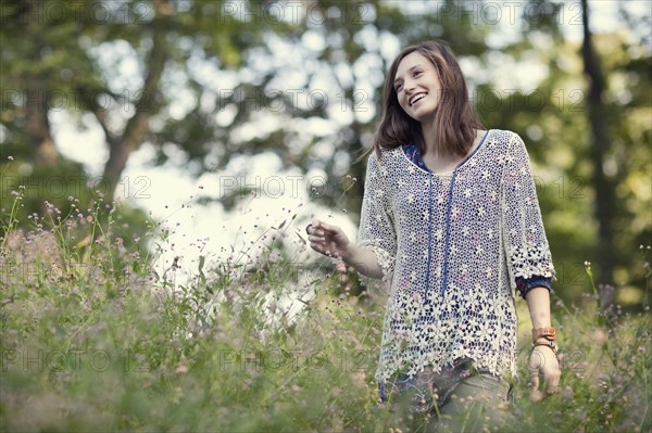 Girl walking in tall grass in forest