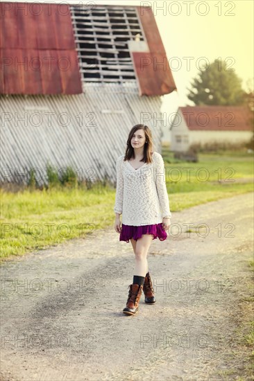 Girl walking on dirt path in rural farm