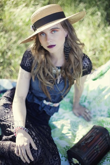 Stylish woman sitting on blanket