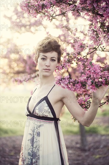 Woman walking under flowering trees in garden