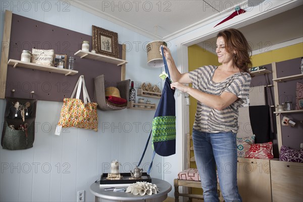 Caucasian business owner arranging items in store