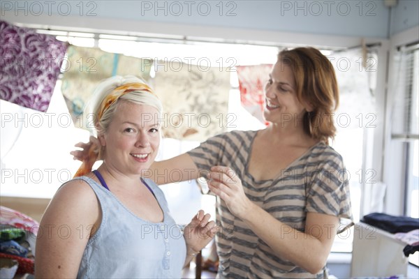 Caucasian business owner assisting customer with headscarf