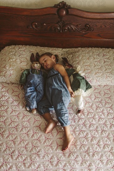 Hispanic girl napping on bed