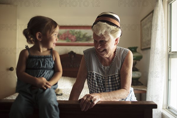 Grandmother and granddaughter playing on bed