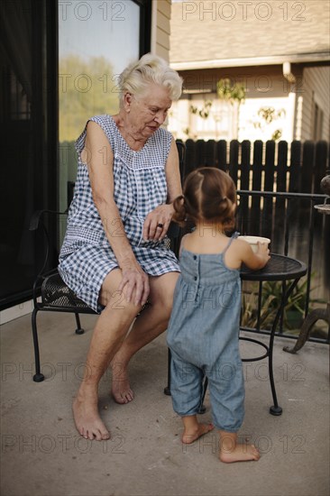 Grandmother and granddaughter playing on patio