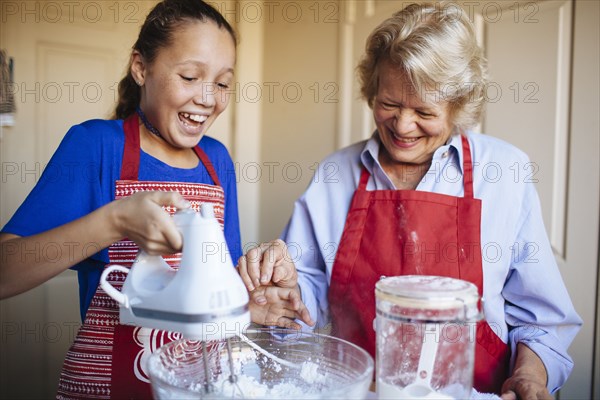 Grandmother and granddaughter baking in kitchen