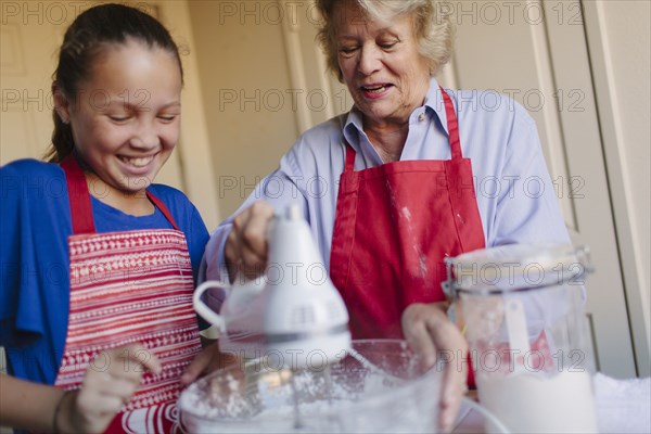 Grandmother and granddaughter baking in kitchen