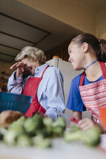 Grandmother and granddaughter cooking in kitchen