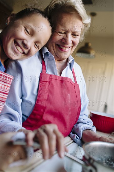 Grandmother and granddaughter using kitchen sink