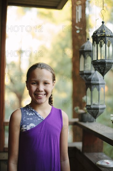 Smiling girl standing on porch