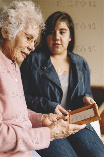 Grandmother and granddaughter admiring old photograph