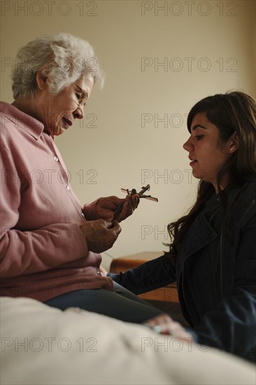 Granddaughter and grandmother praying with crucifix