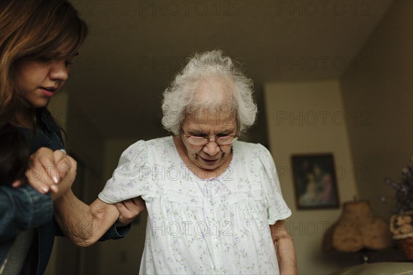 Granddaughter helping grandmother stand