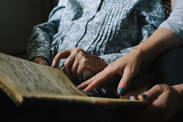 Grandmother and granddaughter reading book