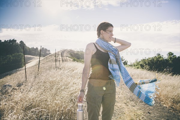 Caucasian woman walking on rural dirt road