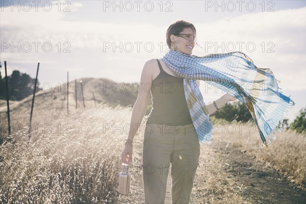 Caucasian woman walking on rural dirt road