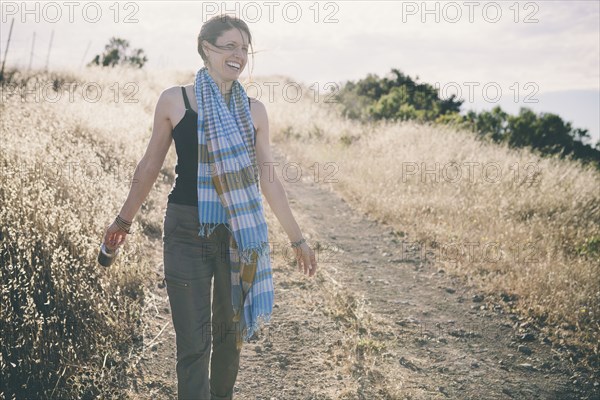 Caucasian woman walking on rural dirt road