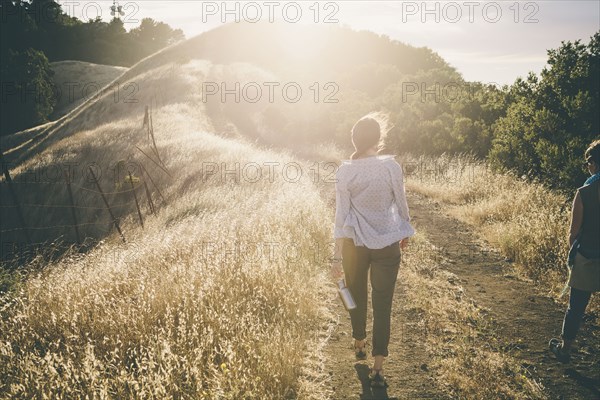 Caucasian woman walking on rural dirt road