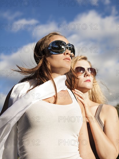 Caucasian women wearing sunglasses and looking up