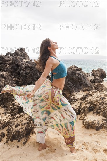 Woman dancing on rocky beach