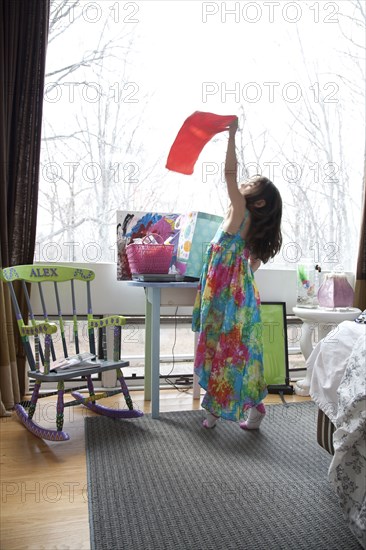 Caucasian girl playing in bedroom