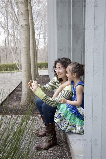 Caucasian mother and daughter taking selfie with cell phone