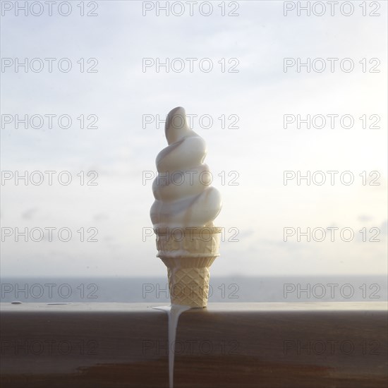 Close up of melting ice cream cone on banister