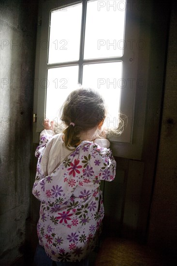 Caucasian girl looking out window