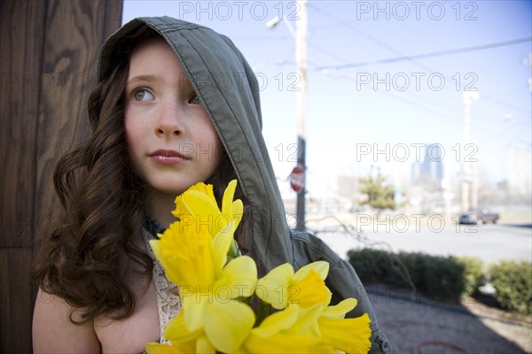 Close up of Caucasian girl holding flowers outdoors