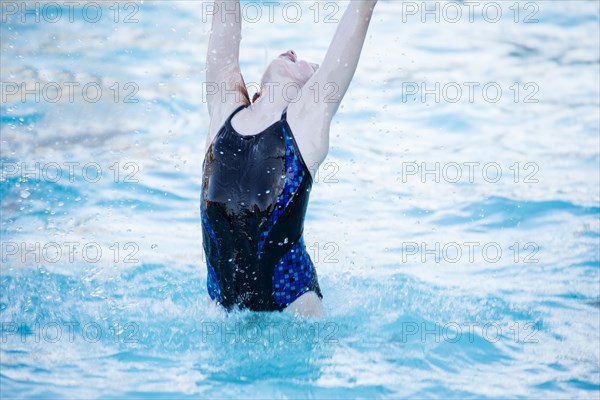 Caucasian girl splashing in swimming pool