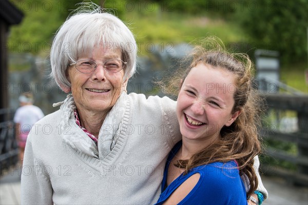 Grandmother and granddaughter hugging at park