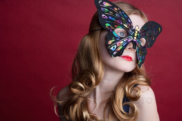 Close up of Caucasian girl wearing butterfly mask
