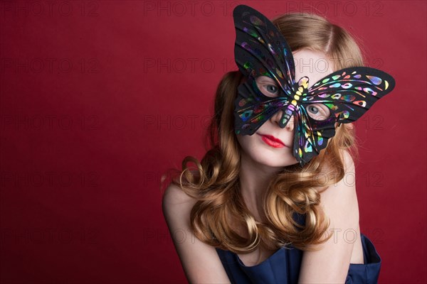 Close up of Caucasian girl wearing butterfly mask