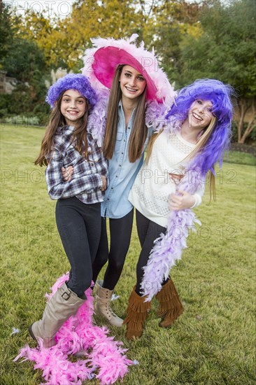 Caucasian teenage girls wearing feather boas and costumes