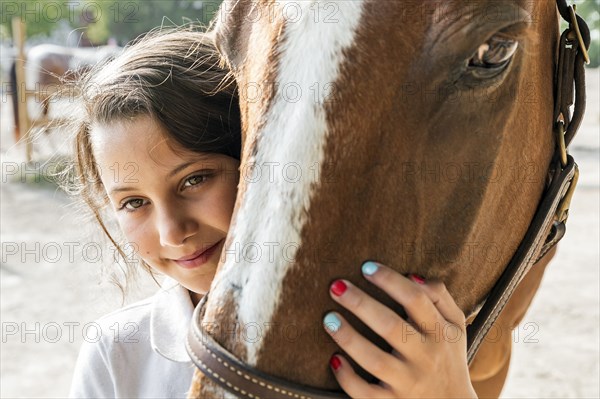 Close up of teenage girl hugging horse