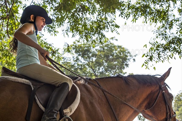 Low angle view of equestrian girl riding horse