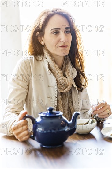 Caucasian woman drinking tea at table