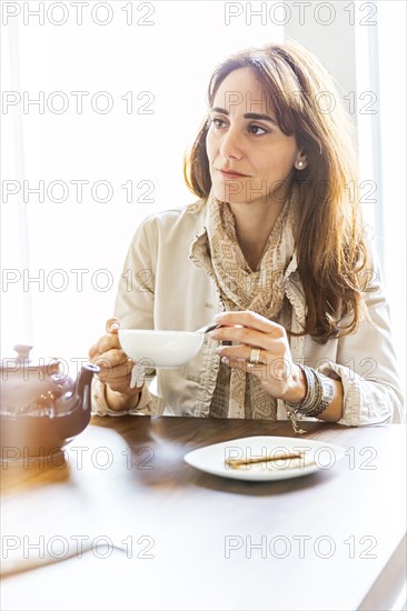 Caucasian woman drinking tea at table