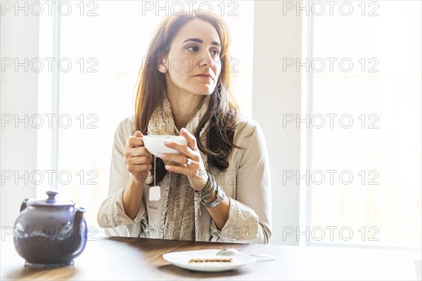 Caucasian woman drinking tea at table