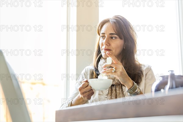 Caucasian woman drinking tea at table